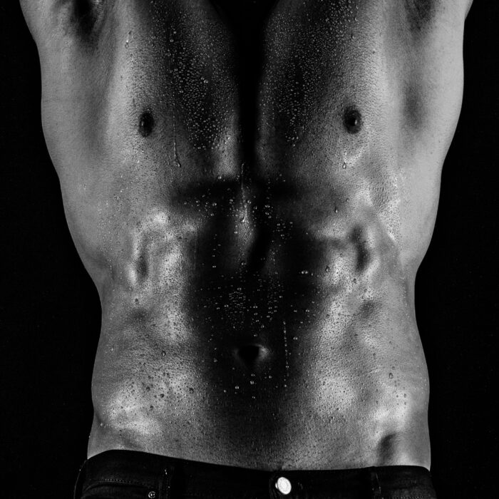 Muskulöse Aktfotografie Kunst eines Oberkörpers eines Mannes. Der Aktfotograf fing den Oberkörper in schwarz-weiss ein . Die Arme sind nach oben gehalten. Sinnliche Erotikshootings für Erinnerungen sind bei uns immer buchbar.