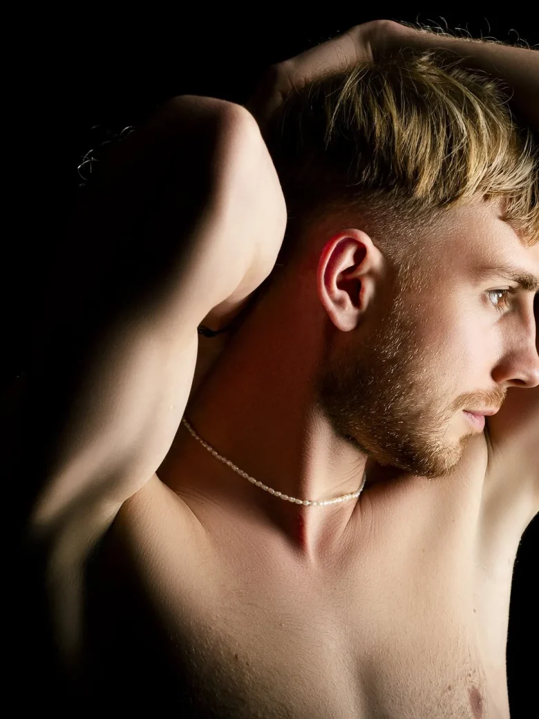 Aktfotografie für Männer – elegantes Profil-Porträt mit Perlenkette in warmem Licht, Studio Hitzkirch Luzern