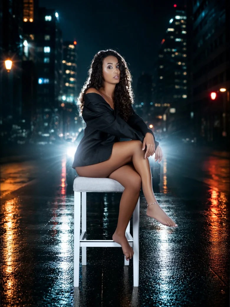 Luxury Boudoir Fotografie – Frau im Blazer auf einem Hocker vor nächtlicher Skyline, Studio Hitzkirch Luzern